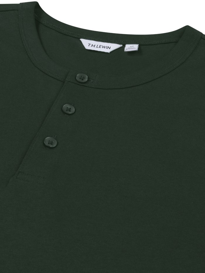 Close-up shot of the placket buttons on an emerald green Henley shirt's neckline