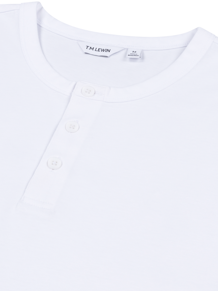 Close-up shot of the placket buttons on a white Henley shirt's neckline